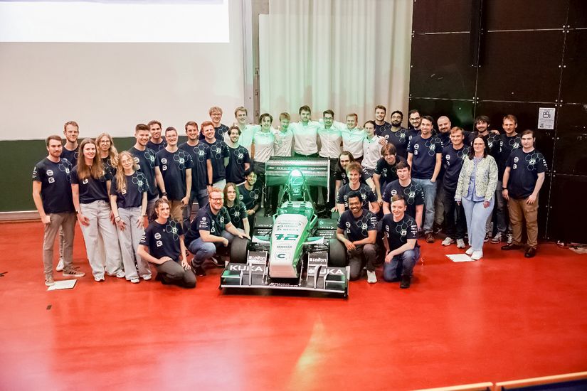 Team von Bremergy auf der Bühne. Vor dem Team aus Studentinnen und Studenten der Hochschule Bremen und der Universität Bremen steht der von ihnen konstruierte Rennwagen.