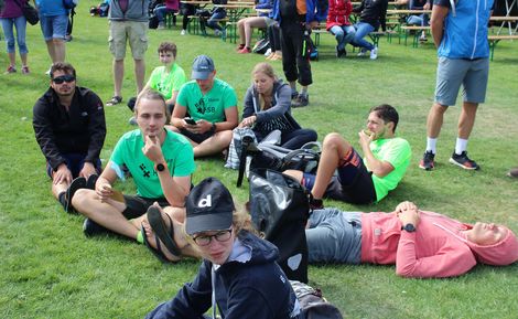 Mitglieder der HSB TriRunners sitzen entspannt auf einer Wiese.