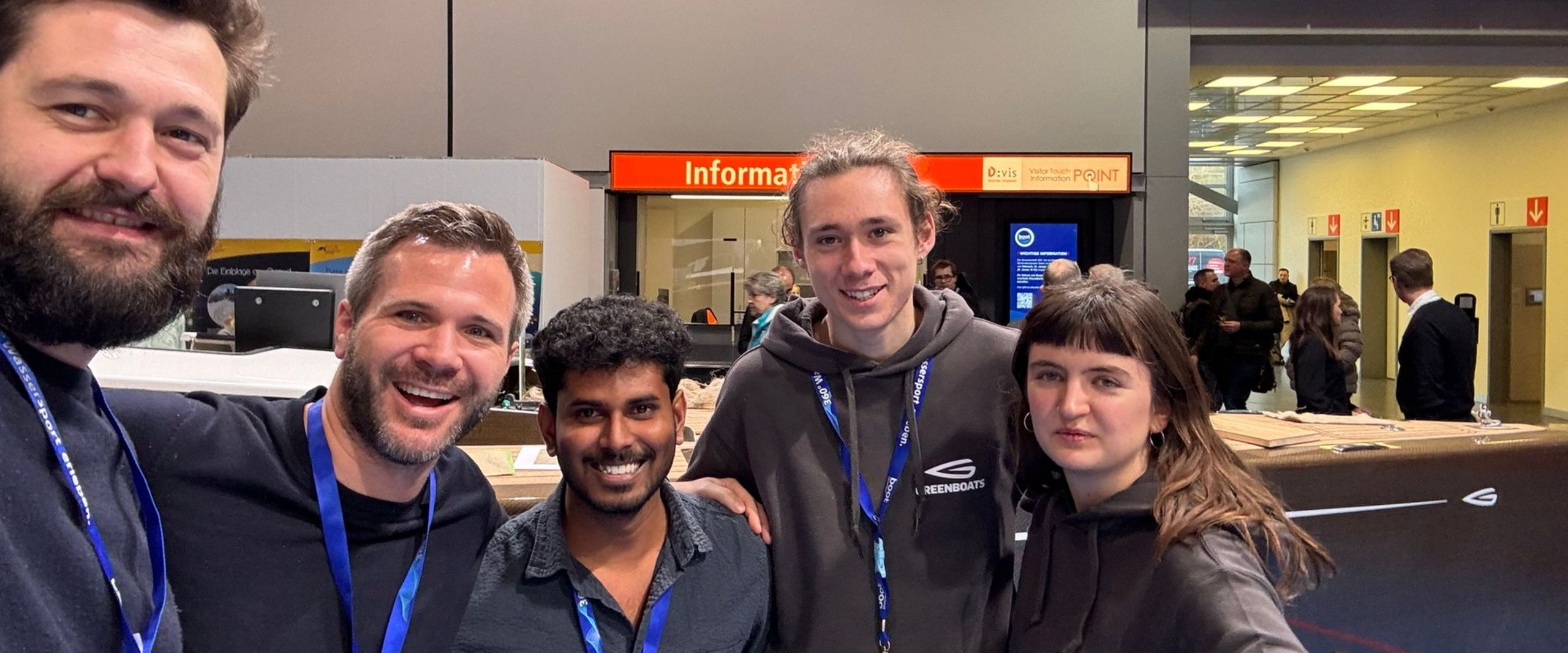 Gruppenbild mit f&uuml;nf M&auml;nnern, die in die Kamera lachen.