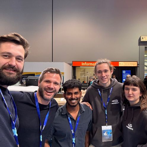 Gruppenbild mit f&uuml;nf M&auml;nnern, die in die Kamera lachen.