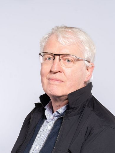 Auf dem Foto ist Jürgen Westhof zu sehen. Er hat kurzes graues Haar, trägt eine Brille und eine dunkle Jacke.