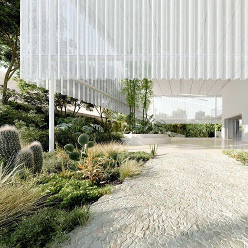 Das Bild zeigt den Ausschnitt eines modernen, wei&szlig;en Geb&auml;udes mit Weg und Gr&uuml;nbepflanzung am Rande