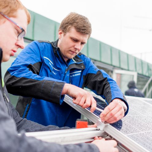 Zwei M&auml;nner arbeiten an einer Solaranlage