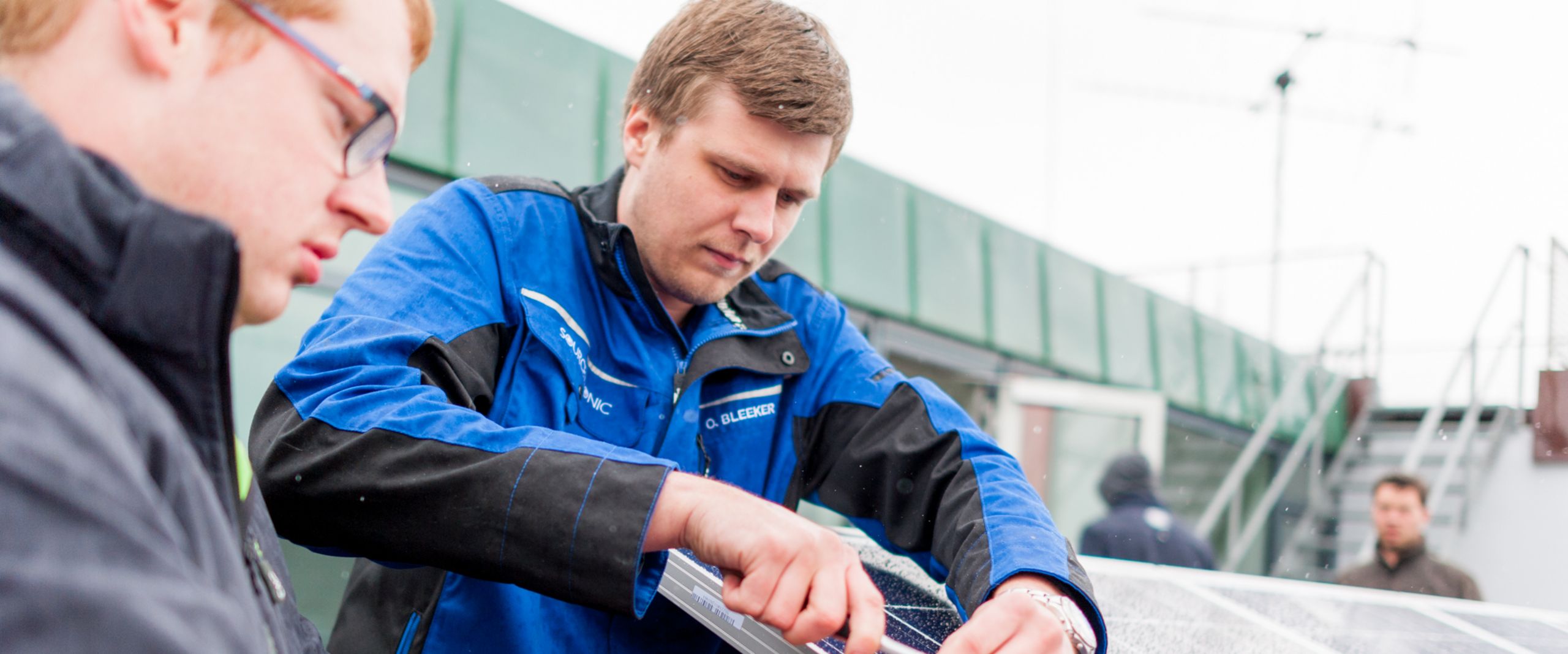 20240115_Illu PM Konferenz Green Deal Zwei Männer arbeiten an einer Solaranlage