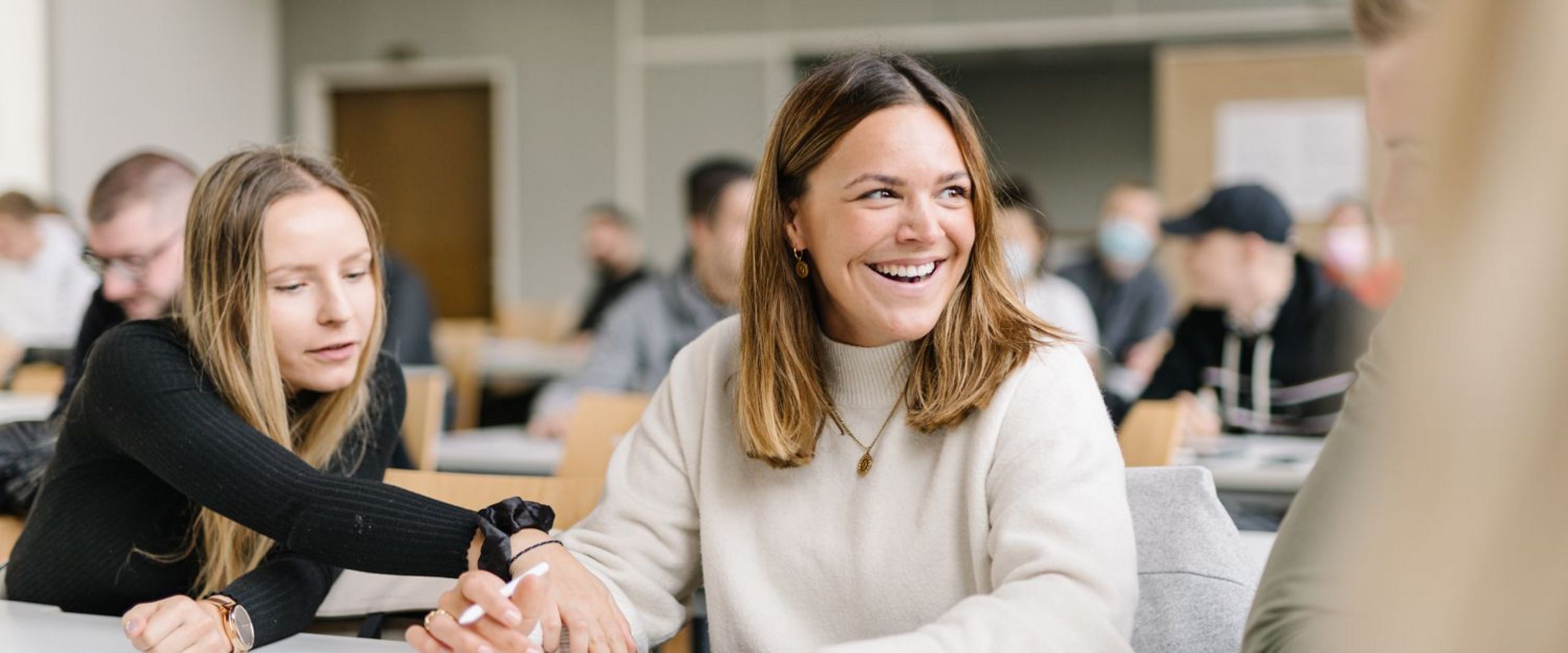 Studentinnen vom Studiengang Management im Handel unterhalten sich bei einer Gruppenarbeit in einer Veranstaltung.