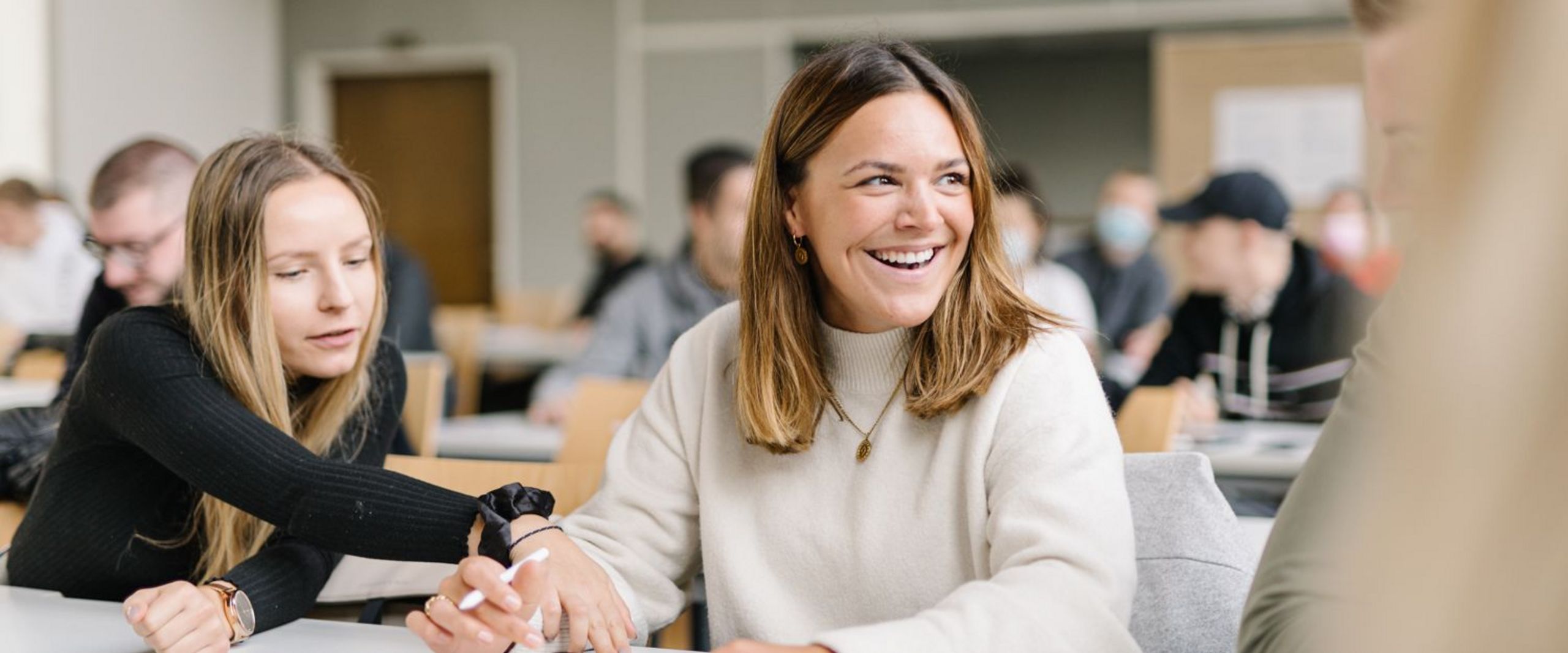 Studentinnen vom Studiengang Management im Handel unterhalten sich bei einer Gruppenarbeit in einer Veranstaltung.