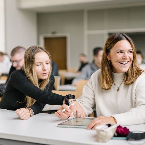 Studentinnen vom Studiengang Management im Handel unterhalten sich bei einer Gruppenarbeit in einer Veranstaltung.