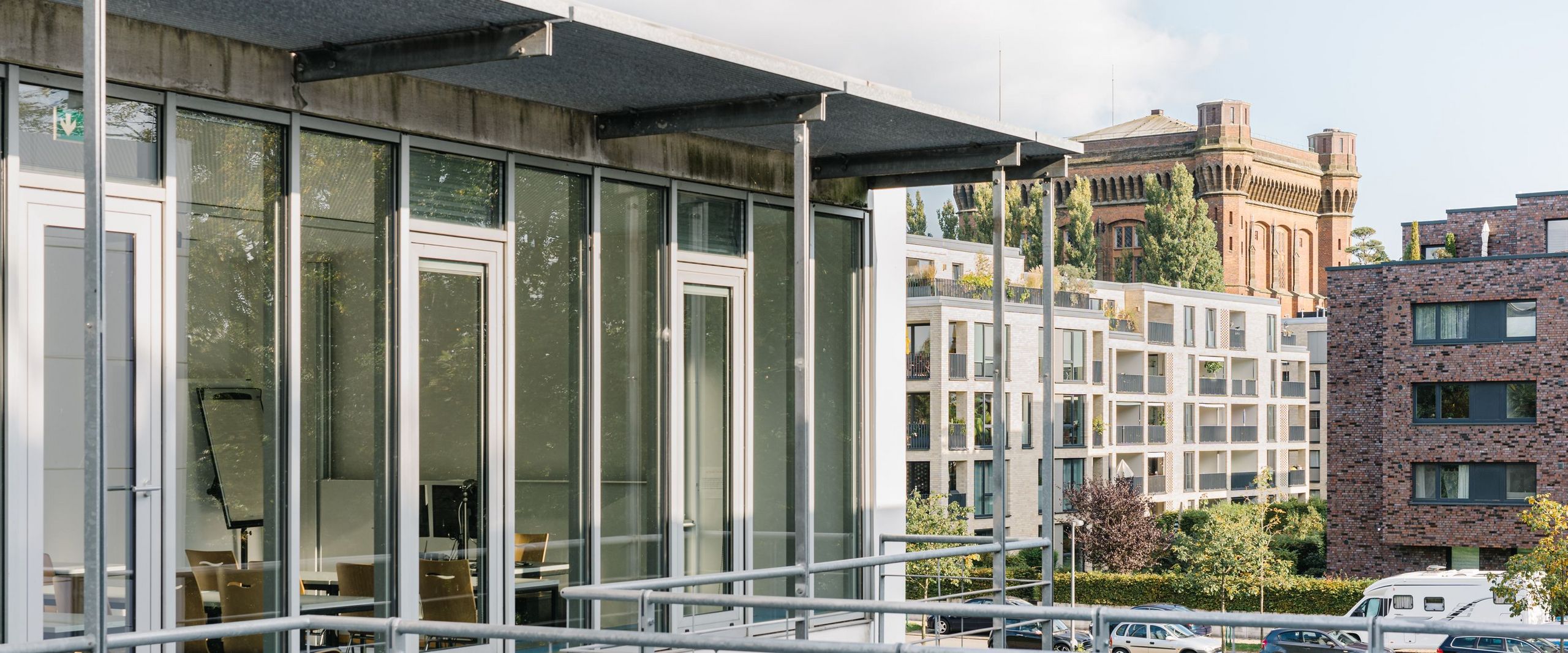 Ein Bild von dem neuen HSB-Gebäude am Campus Werderstraße. Im Hintergrund sieht man moderne Mehrfamilienhäuser sowie den alten Wasserturm auf dem Werder, der auch die "Umgedrehte Kommode" genannt wird.