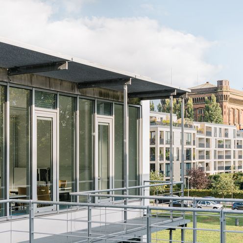Ein Bild von dem neuen HSB-Geb&auml;ude am Campus Werderstra&szlig;e. Im Hintergrund sieht man moderne Mehrfamilienh&auml;user sowie den alten Wasserturm auf dem Werder, der auch die "Umgedrehte Kommode" genannt wird.