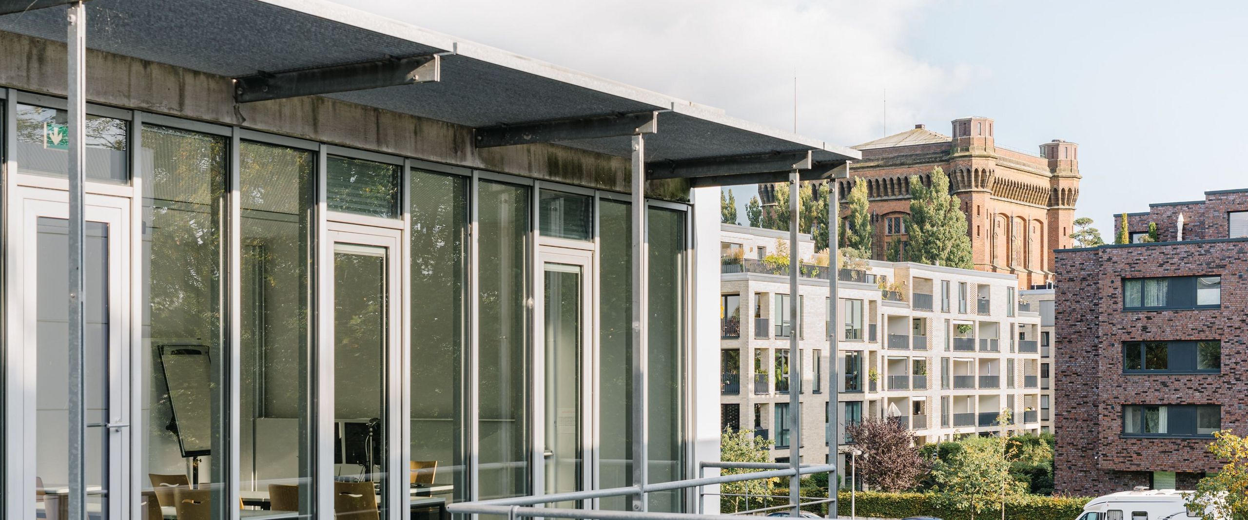 Ein Bild von dem neuen HSB-Gebäude am Campus Werderstraße. Im Hintergrund sieht man moderne Mehrfamilienhäuser sowie den alten Wasserturm auf dem Werder, der auch die "Umgedrehte Kommode" genannt wird.