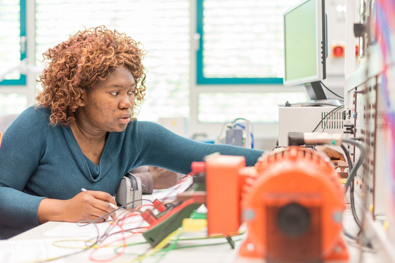 Studentin macht sich Notizen im Labor für Elektrotechnik. 