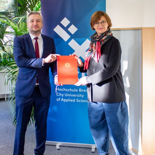 Kanzler Daniel Engelbrecht &uuml;berreicht Prof. Dr. Svenja Tams eine Urkunde ihrer Berufung als Professorin an die HSB.