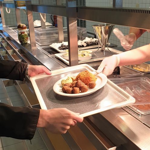 Tablett mit Essen bei der Ausgabe in der Mensa