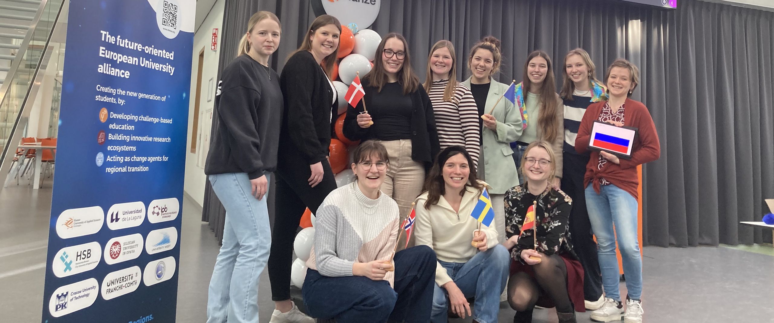 Gruppenbild mit weiblichen Studierenden. Neben ihnen steht ein STARS EU Roll up. Im Hintergrund sieht man einen gro&szlig;en Monitor mit Logos.
