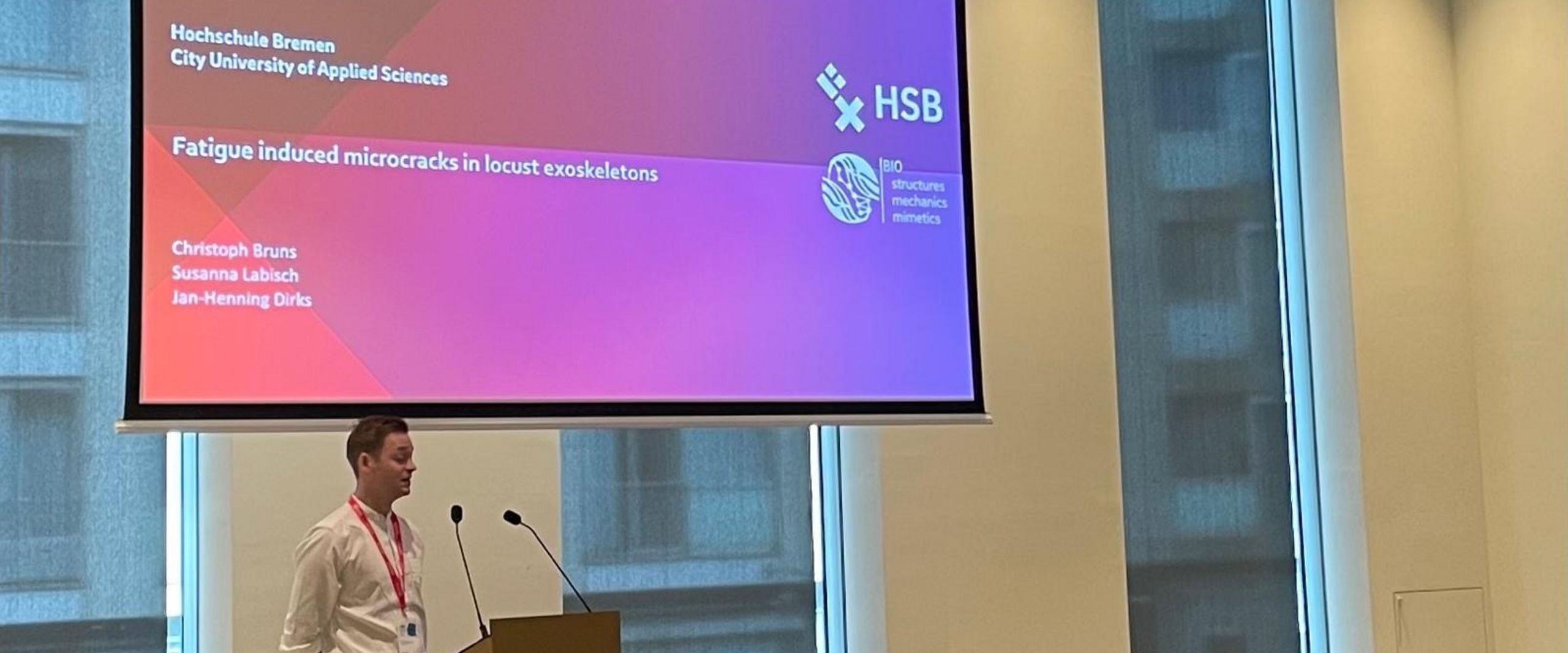 2025_SEB_talk_Bruns Christoph Bruns bei seinem Vortrag bei der SEB-Tagung. Er steht vor der Projektionsfläche seiner Präsentation.