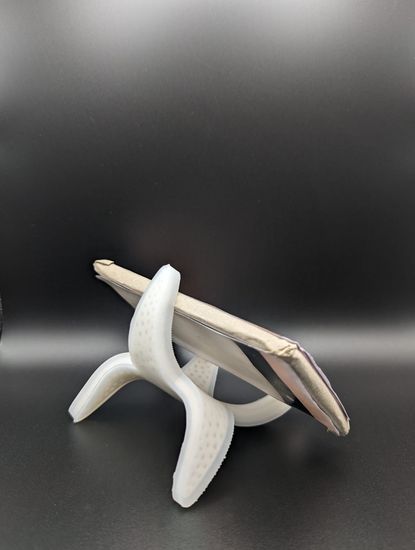 Handy steht in weißer Halterung