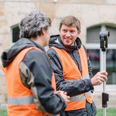 Zwei Männer mit organgen Warnwesten