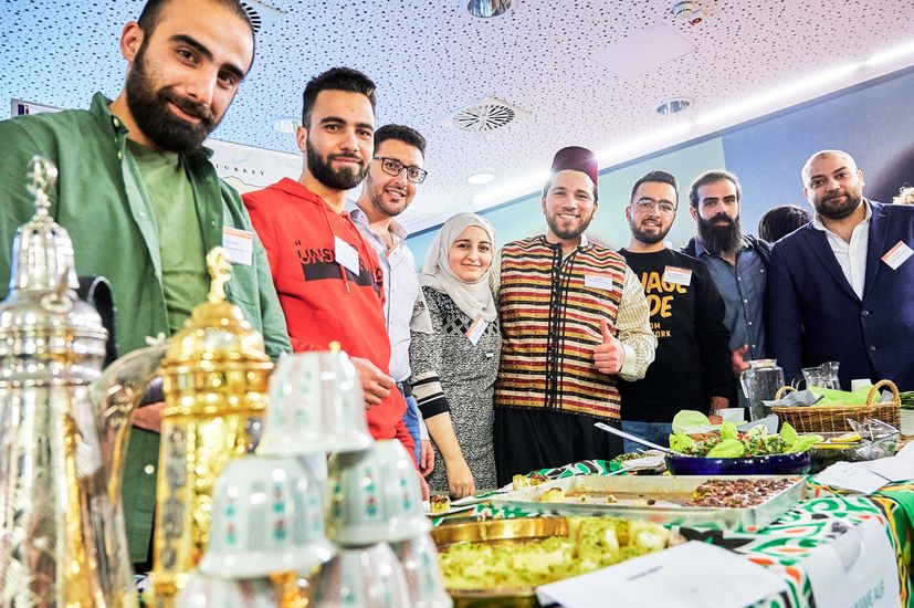 Eine Gruppe von Studierenden am Ländertisch Syrien mit landestypischen Speisen und Getränken beim International Day 2019