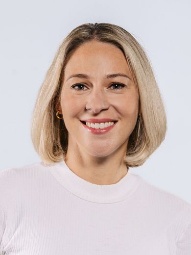 Auf dem Bild ist Alexandra Hashem-Wangler zusehen. Sie hat kinnlanges blondes Haar und trägt ein weißes Shirt.