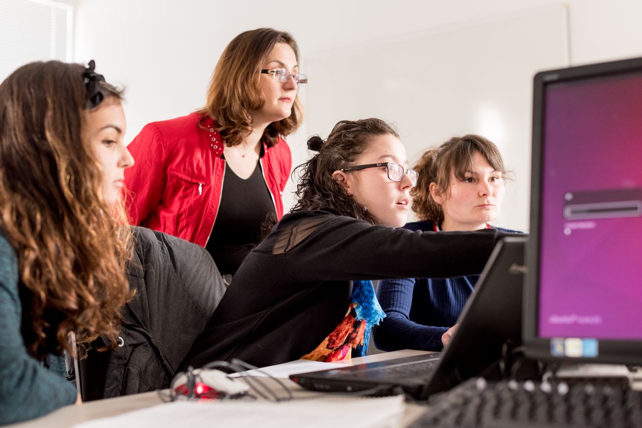 Mädchen und eine Fraue schauen auf einen PC
