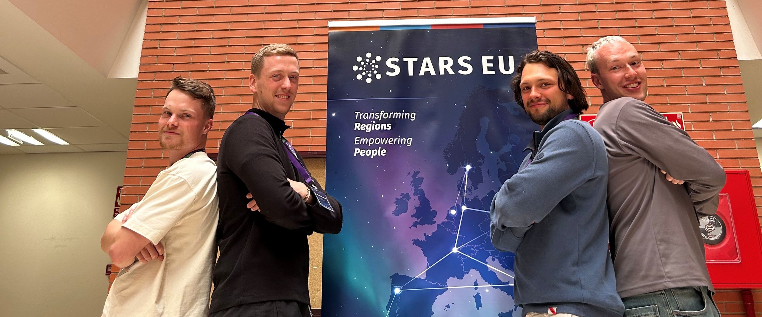 BIP Teneriffa Smart grids STARS EU Drei Männer stehen links und rechts von einem Roll-up und lächeln in die Kamera.