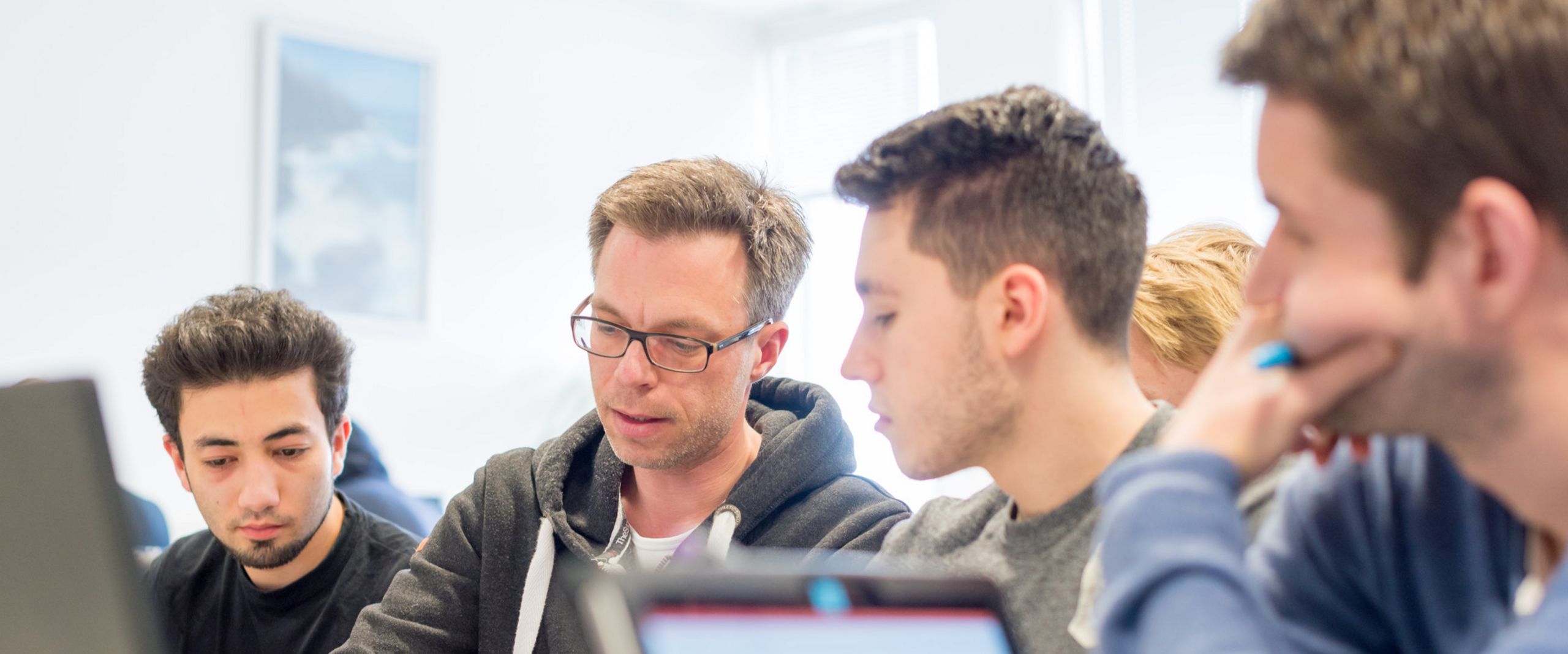 Prof. Dr. Thorsten Teschke macht Aufzeichnungen f&uuml;r drei Studenten. 