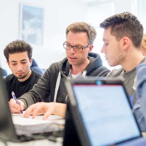 Prof. Dr. Thorsten Teschke macht Aufzeichnungen f&uuml;r drei Studenten. 