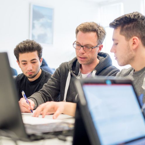 Prof. Dr. Thorsten Teschke macht Aufzeichnungen f&uuml;r drei Studenten. 