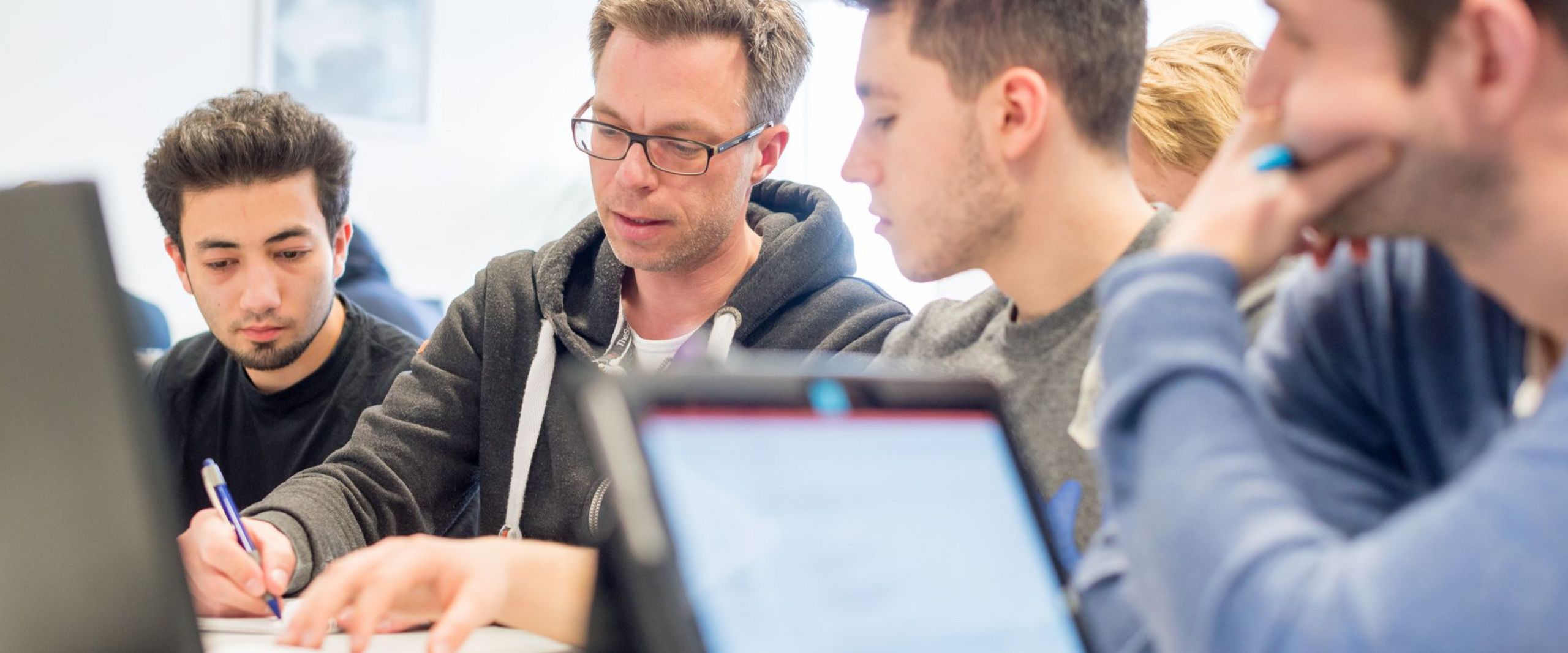 Prof. Dr. Thorsten Teschke macht Aufzeichnungen für drei Studenten. 