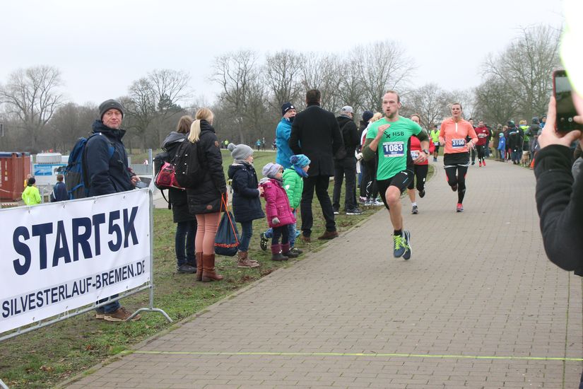 Auf der Laufstrecke sind mehrere L&auml;ufer zu sehen und Publikum an der Seite. 