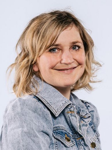 Auf dem Bild ist Constanze Hartung zusehen. Sie hat schulterlanges welliges blondes Haar und trägt eine hellblaue Jeansjacke. 
