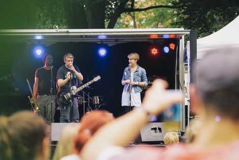 Konzert beim HSB Sommerfest. Drei Musiker:innen stehen auf der Bühne.