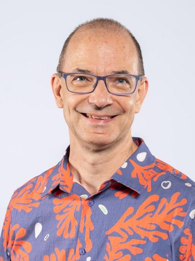 Auf dem Foto ist Volker Paelke zusehen. Er hat eine Halbglatze. Er tr&auml;gt eine Brille und ein blaues Hemd mit einem orangen Pflanzendruck.