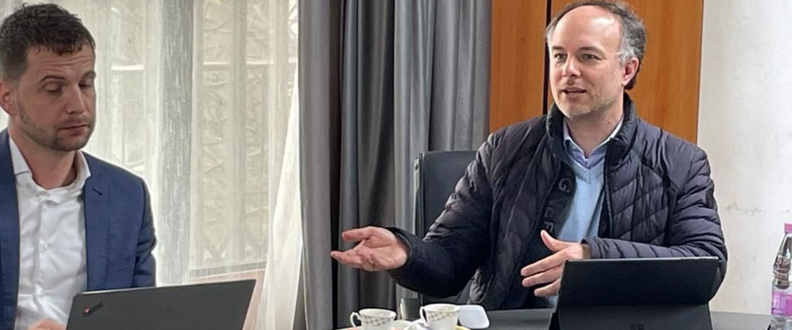 Prof. Dr. veith Algerien Beratungsreise Zwie Männer am Tisch. einer redet, der andere schaut ins Laptop.