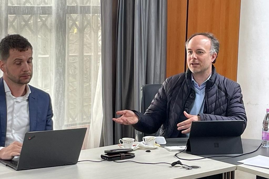 Prof. Dr. veith Algerien Beratungsreise Zwie Männer am Tisch. einer redet, der andere schaut ins Laptop.