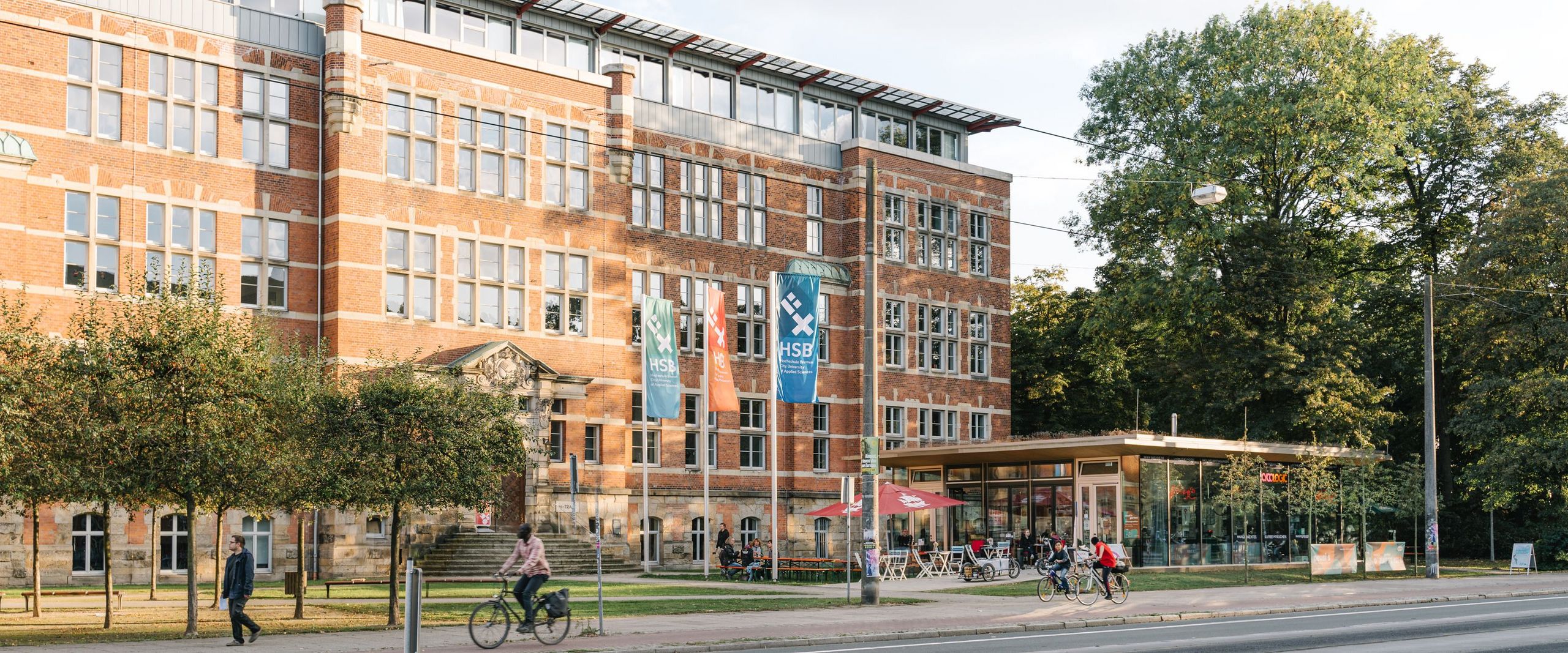 M-Gebäude und Repaircafe "Neuss" umgeben von grünen Bäumen