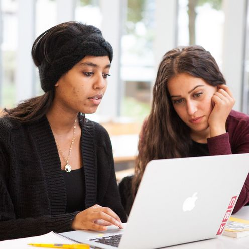 Studentinnen Studentinnen sitzen gemeinsam am Laptop