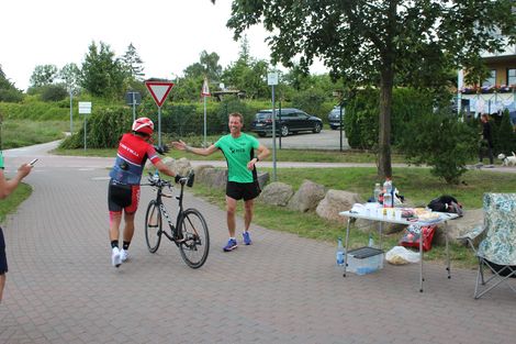 Ein Radfahrer und ein L&auml;ufer klatschen sich ab.