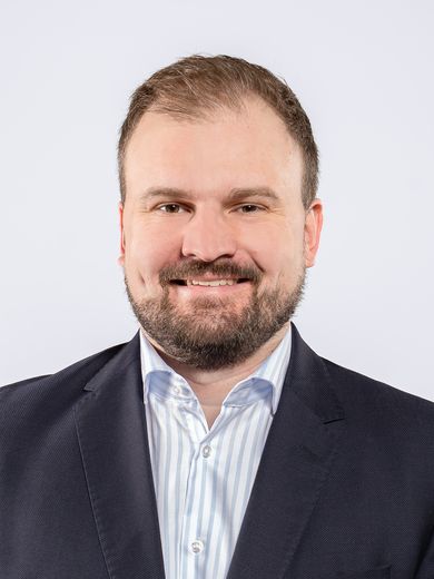 Auf dem Foto ist Tammo M&auml;rtens zusehen. Er hat braune Haare und einen braunen Bart. Er tr&auml;gt ein blau-wei&szlig;-gestreiftes Hemd unter einem dunklen Jacket. 