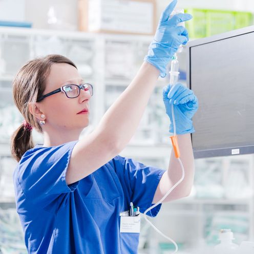 Eine Krankenpflegerin bereitet eine Infusion vor.