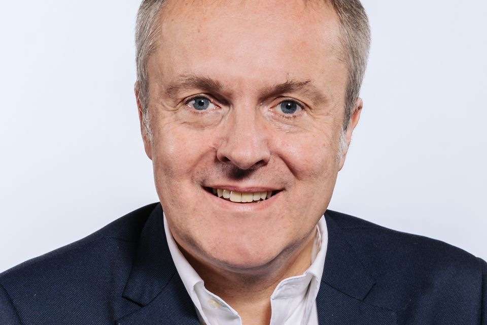 Auf dem Bild ist Lars B&uuml;ttner zusehen. Er hat kurzes graumelliertes Haar und tr&auml;gt ein wei&szlig;es Hemd unter einem dunkel blauen Jacket. 