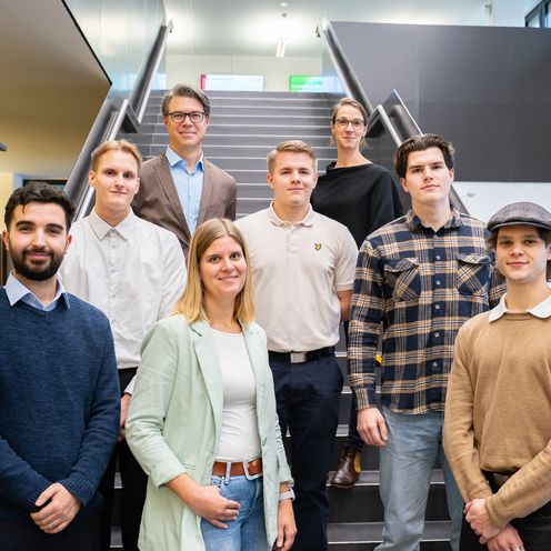 Gruppenfoto: Studierende und Lehrende auf Treppe 