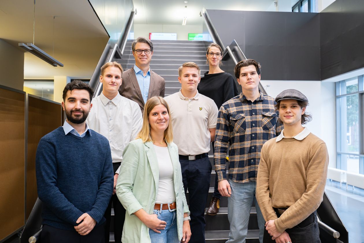 Gruppenfoto: Studierende und Lehrende auf Treppe 