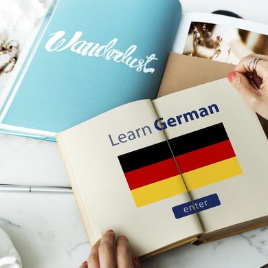 Open book with two German flags and the phrase “Learn German” next to an “enter” button.