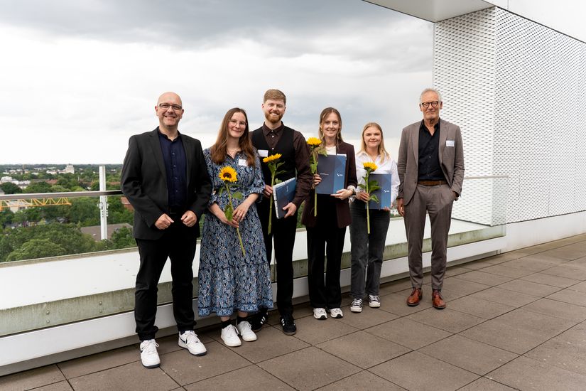 Gruppenbild mit M&auml;nnern und Frauen auf einer Dachterrasse