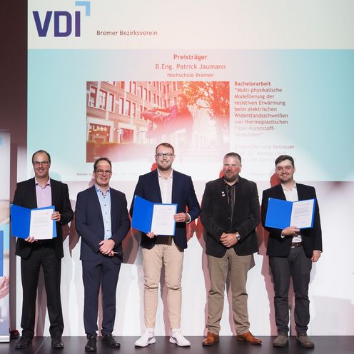 Gruppenbild mit 5 Männern. Drei halten eine Urkunde. 