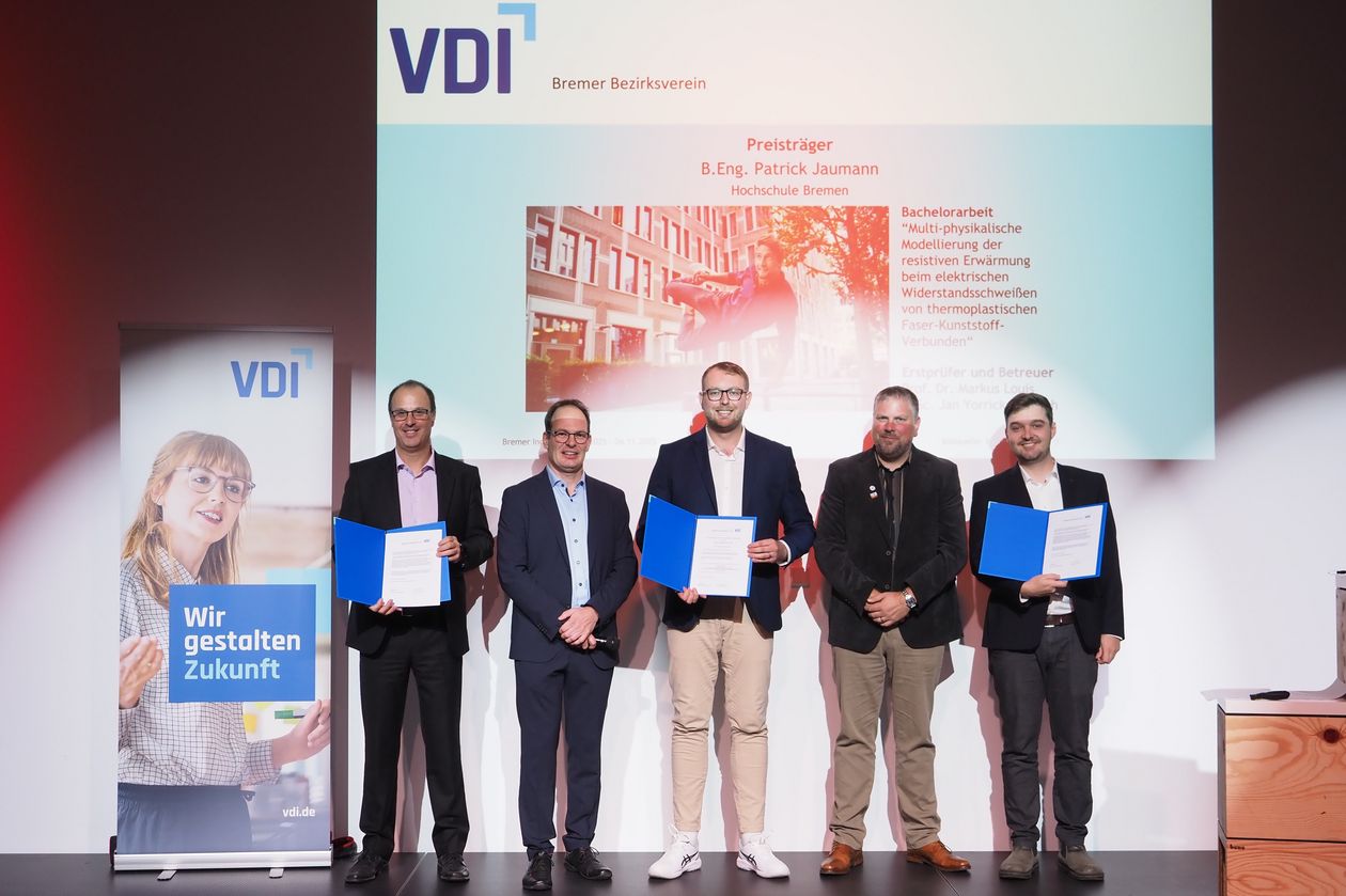 Gruppenbild mit 5 Männern. Drei halten eine Urkunde. 