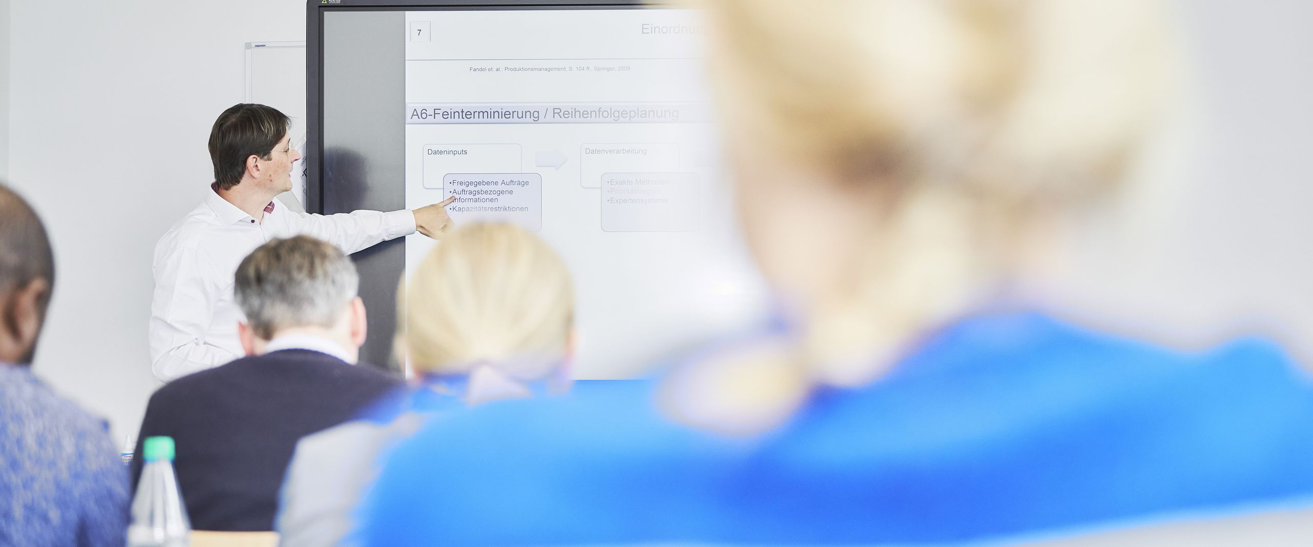 MBA Studierende lauscht Unterricht an der Tafel