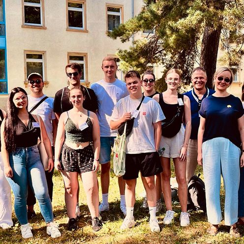 Gruppenfoto im Freien von 13 HSB-Studierenden mit 2 Begleitenden bei der Kinderschutz Sommerhochschule 2024 in Cottbus