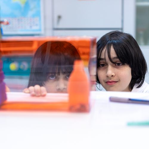 Zwei Kinder schauen in labor &uuml;ber eine Tischkante